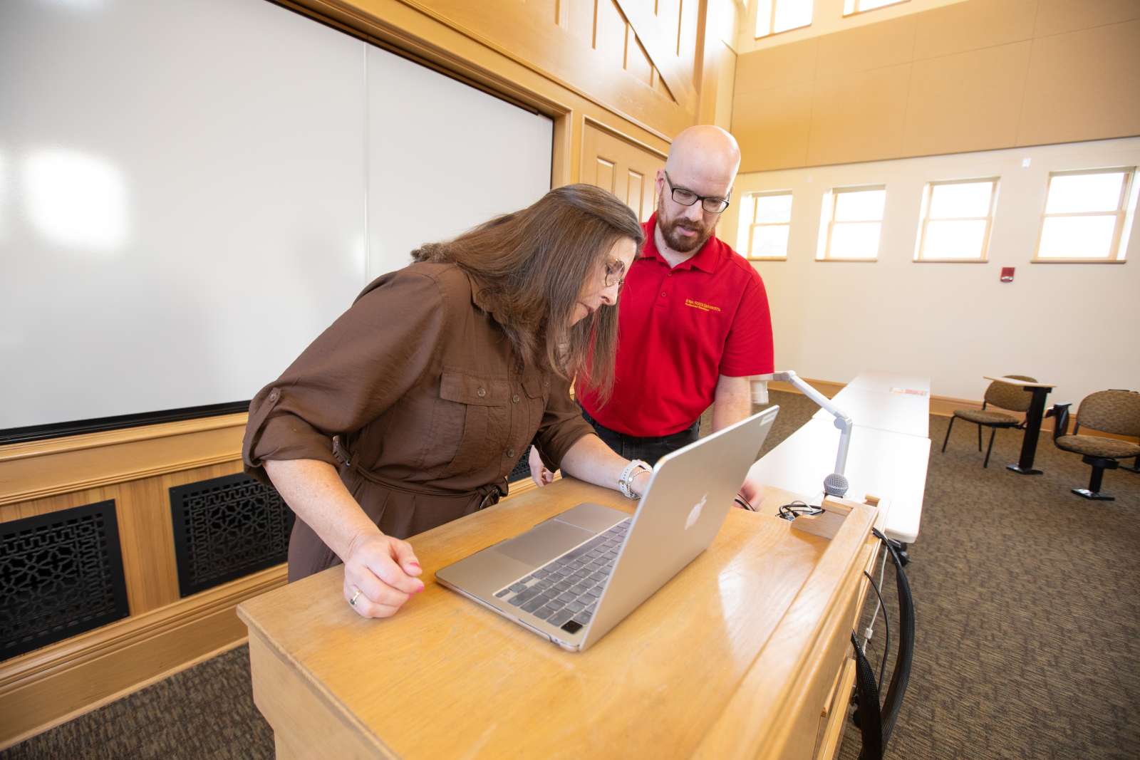 ITS staff helping a faculty member with technology.